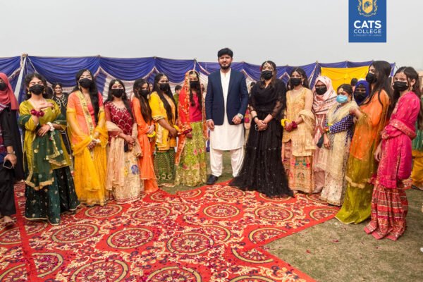 Vibrant student activities at an intermediate college in Lahore featuring traditional dance performances in a decorated campus hall.