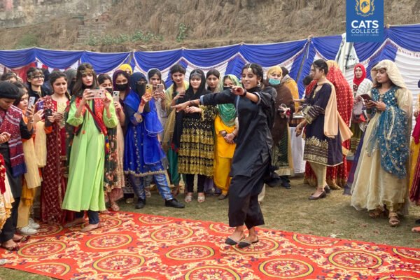 Vibrant student activities at an intermediate college in Lahore featuring traditional dance performances in a decorated campus hall.