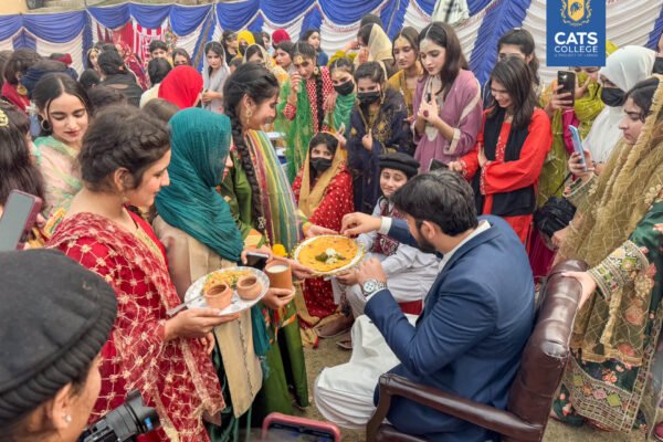 Vibrant student activities at an intermediate college in Lahore featuring traditional dance performances in a decorated campus hall.