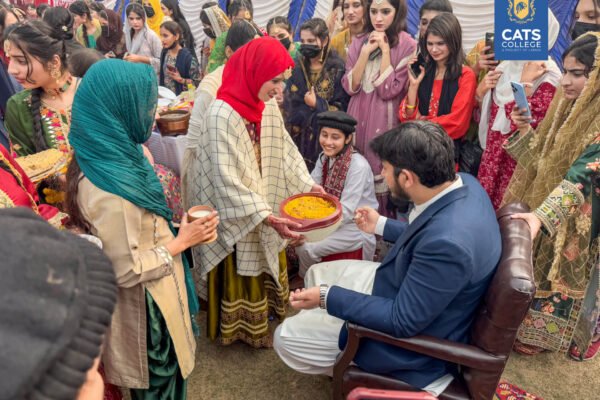 Vibrant student activities at an intermediate college in Lahore featuring traditional dance performances in a decorated campus hall.