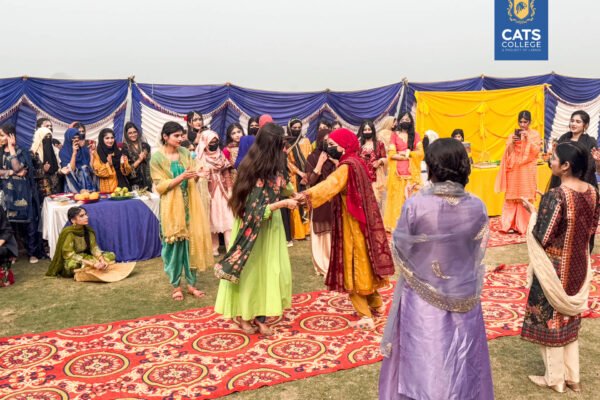 Vibrant student activities at an intermediate college in Lahore featuring traditional dance performances in a decorated campus hall.