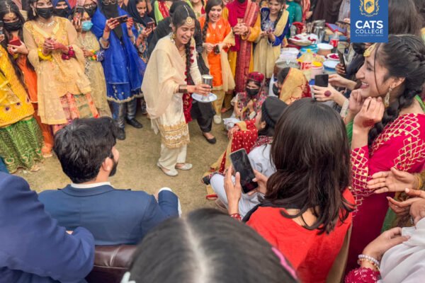 Vibrant student activities at an intermediate college in Lahore featuring traditional dance performances in a decorated campus hall.