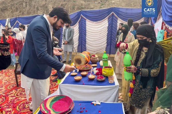 Vibrant student activities at an intermediate college in Lahore featuring traditional dance performances in a decorated campus hall.