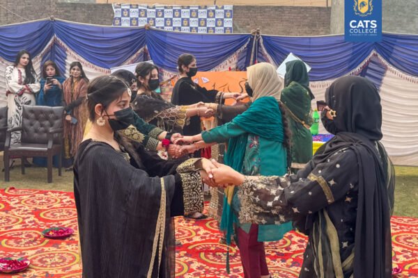 Vibrant student activities at an intermediate college in Lahore featuring traditional dance performances in a decorated campus hall.