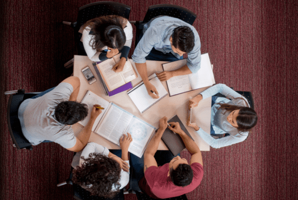 CATS students studying together in a group around a table with books and notebooks